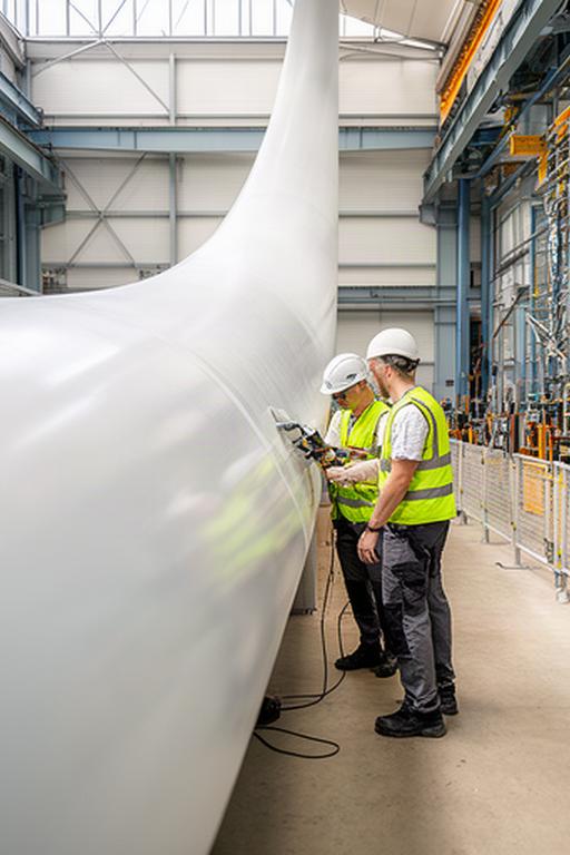 Técnicos revisando una pala de aerogenerador en la planta de fabricación de Conil